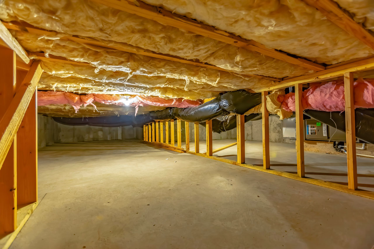 New under-home insulation fitted between the floor joists above a completed ground barrier