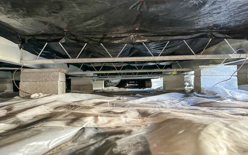Black vapor barrier fastened under the floor joists of a manufactured home